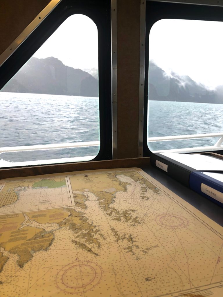 old map and boat window with blue ocean and mountains outside