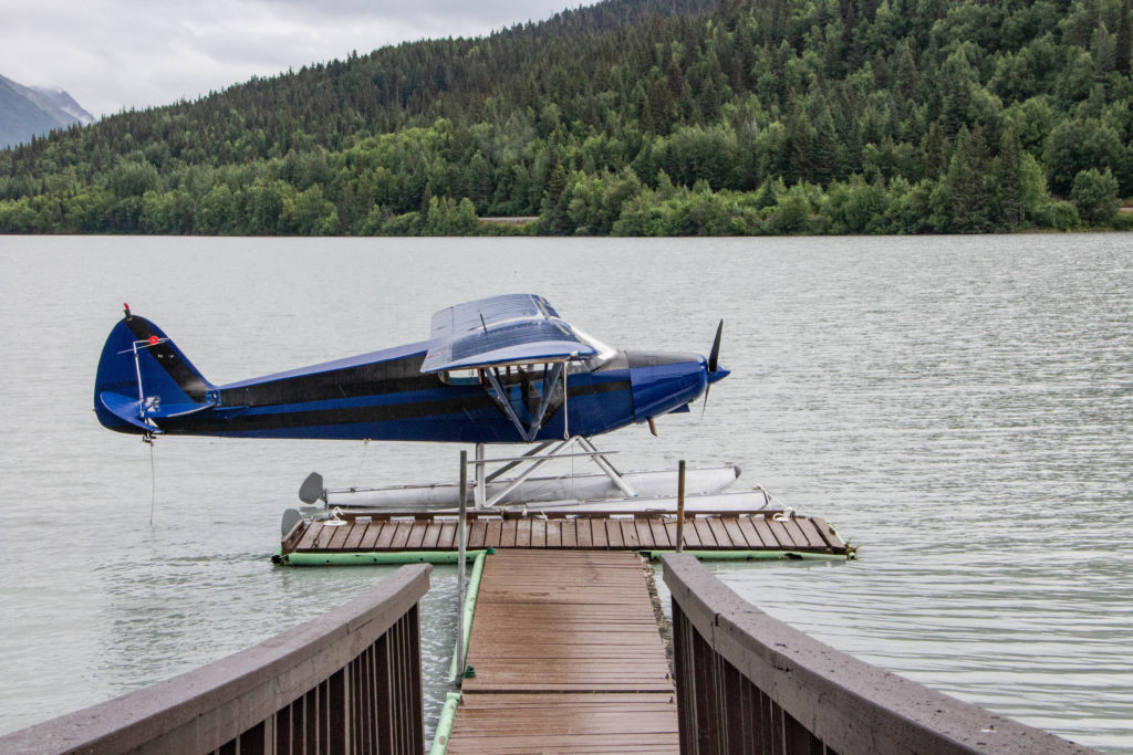 blue airplane on water in moose pass alaska