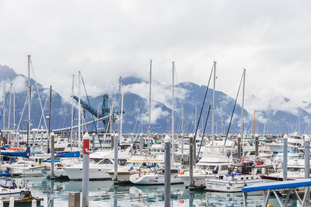Seward Harbor and foggy blue mountains in Alaska with many white boats