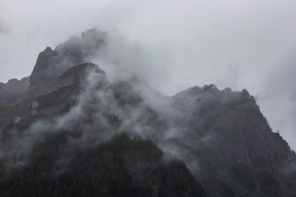 majestic clouds and fog over big black mountains in Seward alaska