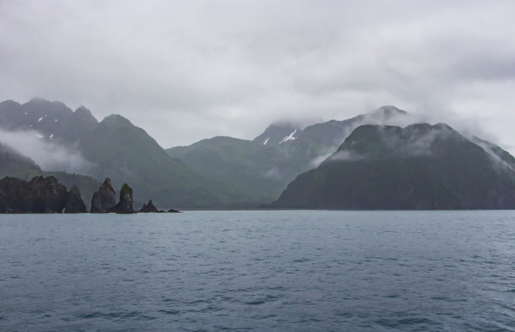 Clouds and fog over mountains, rocks, and ocean in Seward, Alaska