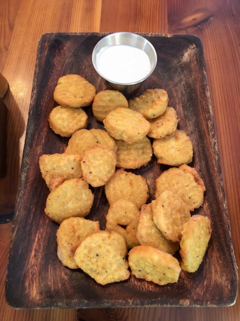 fried pickles slices and ranch dipping sauce on wood table and plate at the outpost pickwick savannah tennessee
