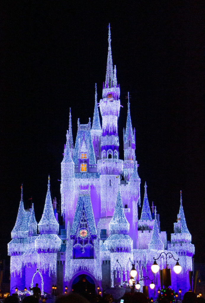 purple christmas lights on cinderella castle at magic kingdom Disney World at Christmas Time